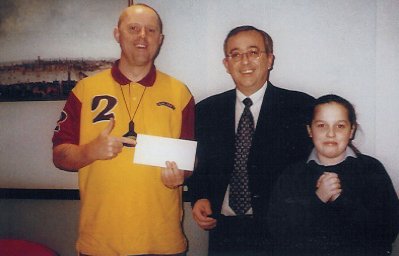 Peter (and Allie) collect the April logo draw cheque from Keith Cain