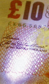 On a real banknote, the value of that note will show up where the light is shining  in the photo. Credit Cards also have secret markings that only show up under the light